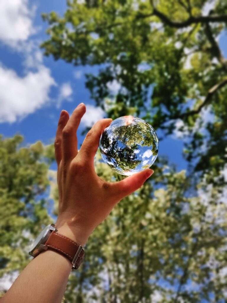 Woman looking through crystal ball into nature.